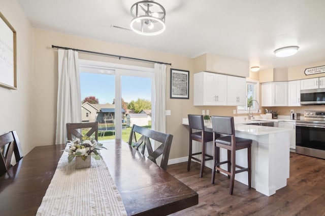 dining room with dark wood-style flooring and baseboards