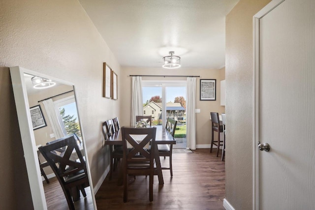 dining room featuring dark wood finished floors and baseboards