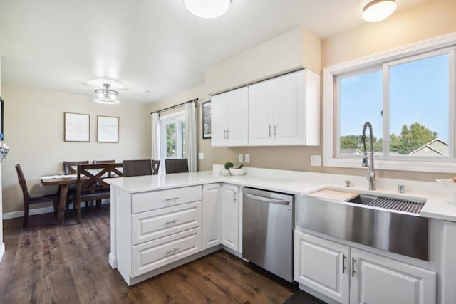 kitchen with a peninsula, stainless steel dishwasher, dark wood-style flooring, and white cabinetry