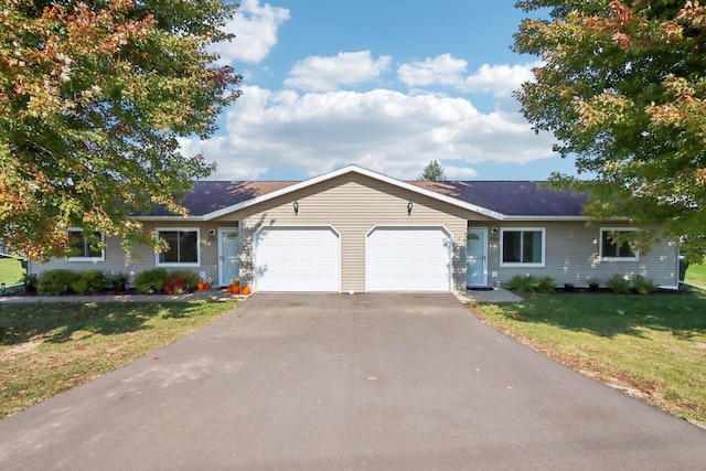 single story home featuring a front yard, driveway, and an attached garage