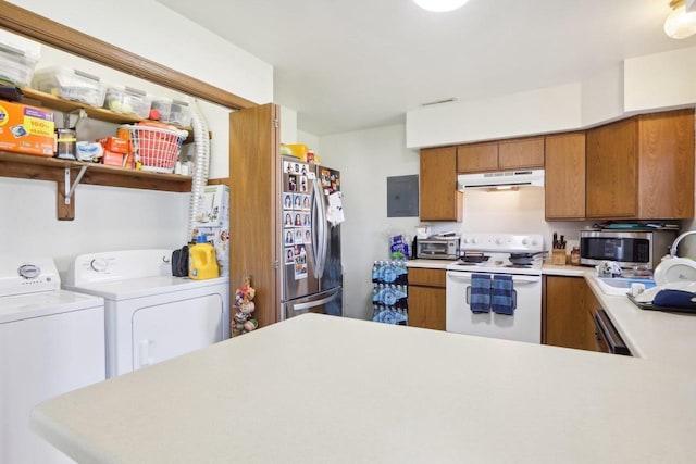 kitchen with brown cabinets, under cabinet range hood, appliances with stainless steel finishes, and separate washer and dryer