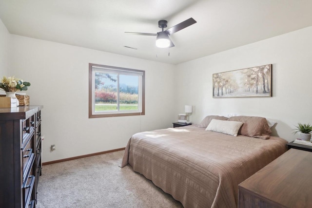 bedroom with visible vents, baseboards, a ceiling fan, and light colored carpet