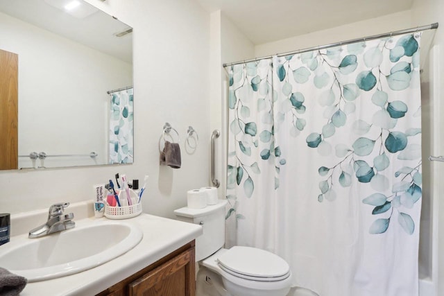 bathroom with curtained shower, vanity, and toilet