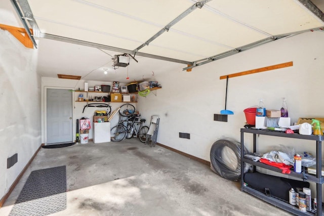 garage with a garage door opener and baseboards