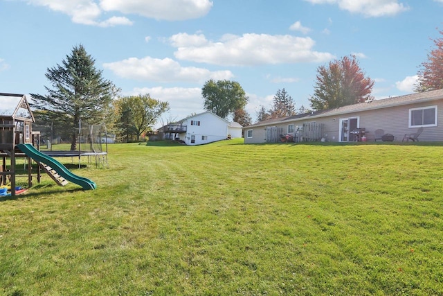 view of yard featuring a trampoline and a playground