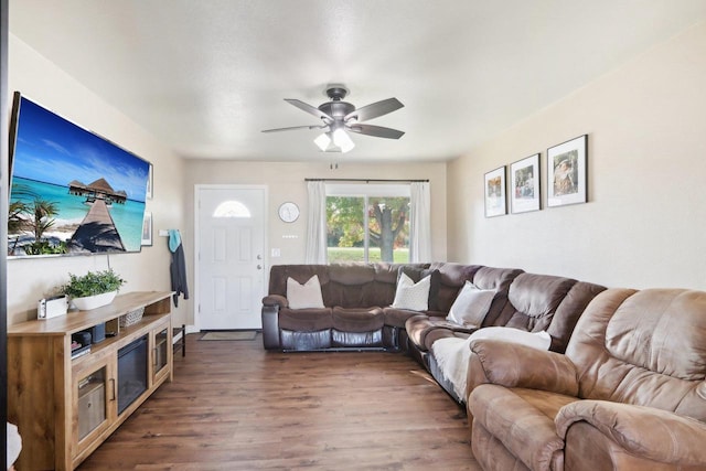 living room featuring dark wood-style floors and a ceiling fan