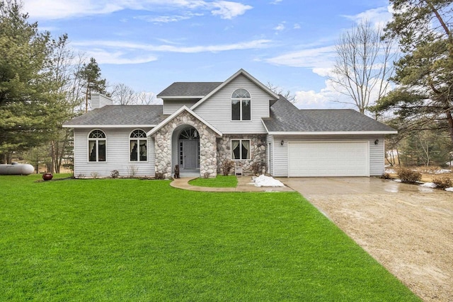 tri-level home with a garage, driveway, stone siding, roof with shingles, and a front lawn