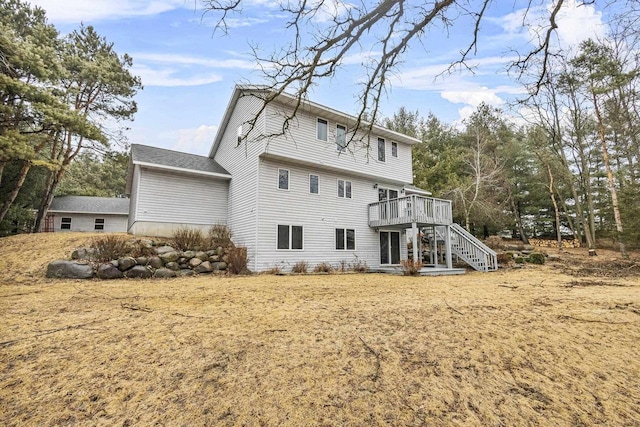 rear view of house featuring stairs and a wooden deck