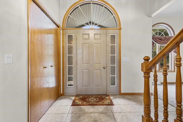 entrance foyer with stairs, baseboards, and light tile patterned floors