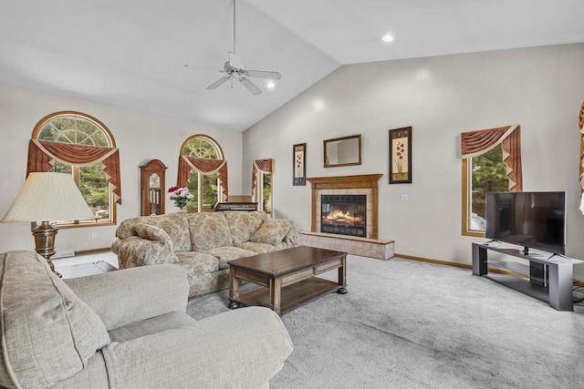 living area with vaulted ceiling, carpet flooring, a tile fireplace, and baseboards