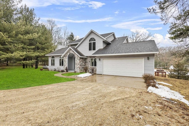 traditional-style house featuring a shingled roof, concrete driveway, stone siding, an attached garage, and a front yard