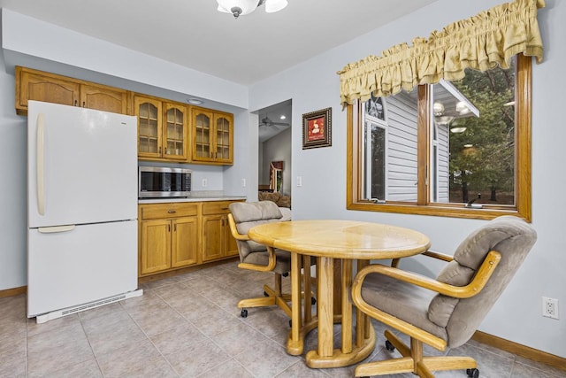 dining space featuring light tile patterned flooring and baseboards