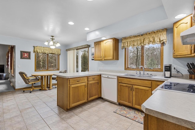 kitchen featuring light countertops, a sink, white appliances, a peninsula, and extractor fan