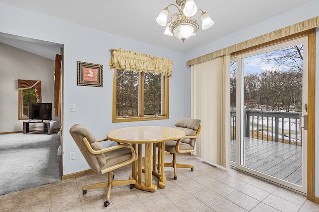 carpeted dining area with a chandelier, a healthy amount of sunlight, and baseboards