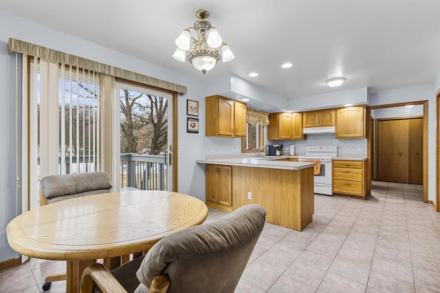 kitchen featuring white range with electric cooktop, light countertops, a sink, a peninsula, and under cabinet range hood