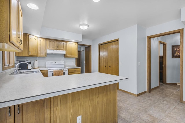 kitchen featuring white range with electric cooktop, light countertops, a sink, a peninsula, and under cabinet range hood