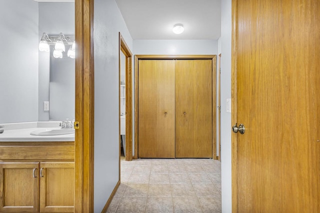 hall with a sink and light tile patterned flooring