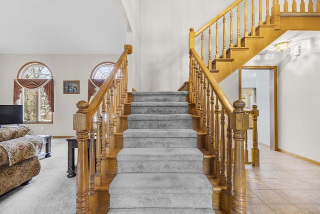 stairway with baseboards and tile patterned floors