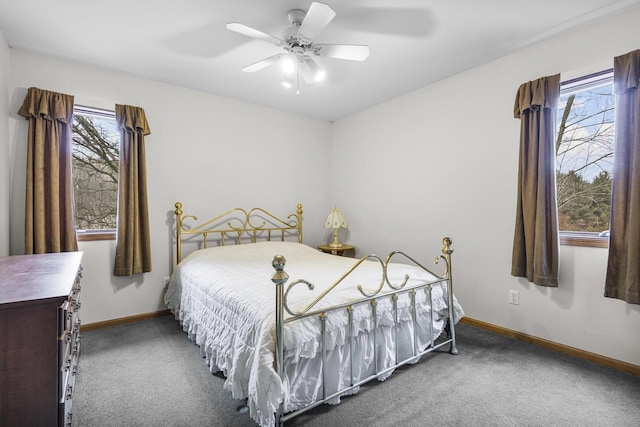 carpeted bedroom featuring ceiling fan, multiple windows, and baseboards