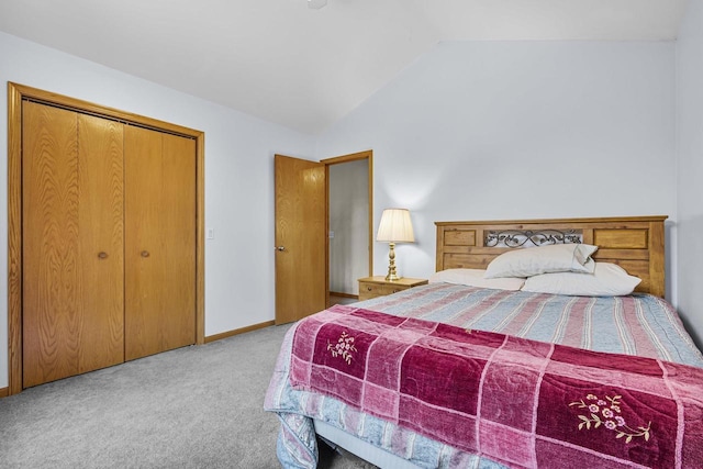 carpeted bedroom with vaulted ceiling, a closet, and baseboards