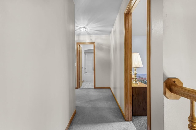 hallway featuring carpet floors and baseboards