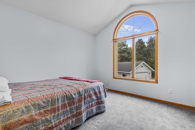 carpeted bedroom featuring vaulted ceiling and baseboards