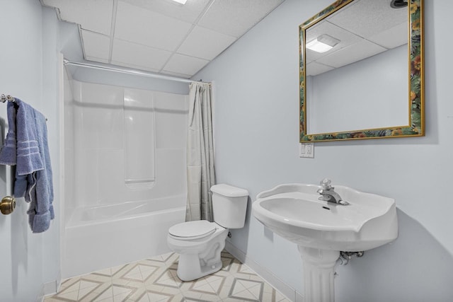 bathroom featuring baseboards, a paneled ceiling, toilet, and shower / bathtub combination with curtain