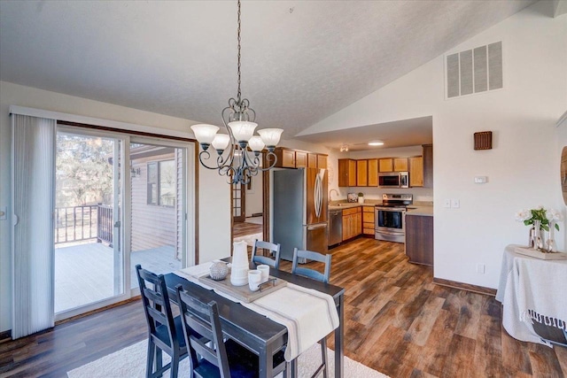 dining area featuring baseboards, visible vents, lofted ceiling, dark wood-type flooring, and a chandelier