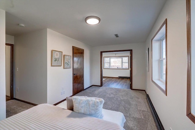 carpeted bedroom featuring visible vents, baseboards, and baseboard heating