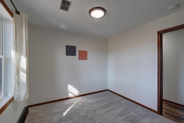 carpeted empty room featuring visible vents and baseboards