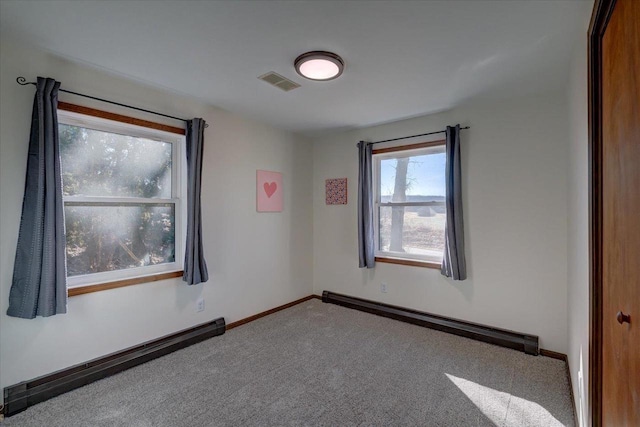 carpeted empty room with visible vents, baseboards, and baseboard heating