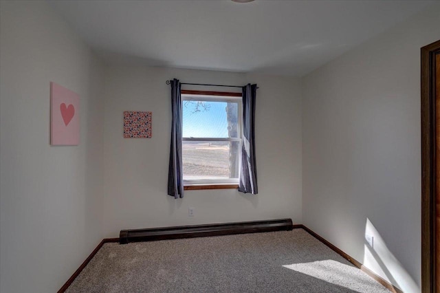 empty room featuring baseboards, a baseboard heating unit, and carpet