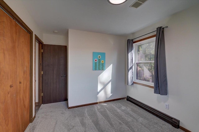 empty room with visible vents, baseboards, and carpet