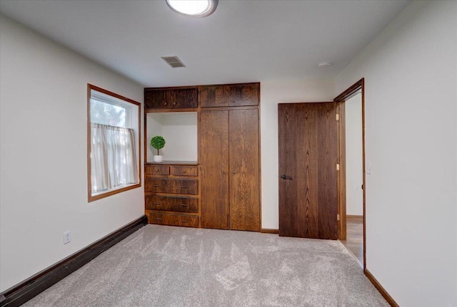 unfurnished bedroom with baseboards, visible vents, a closet, and carpet floors