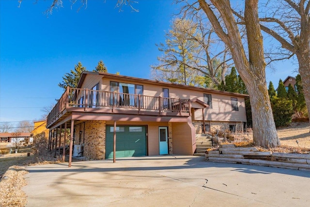 view of front facade featuring a wooden deck, concrete driveway, a garage, central AC unit, and stairs