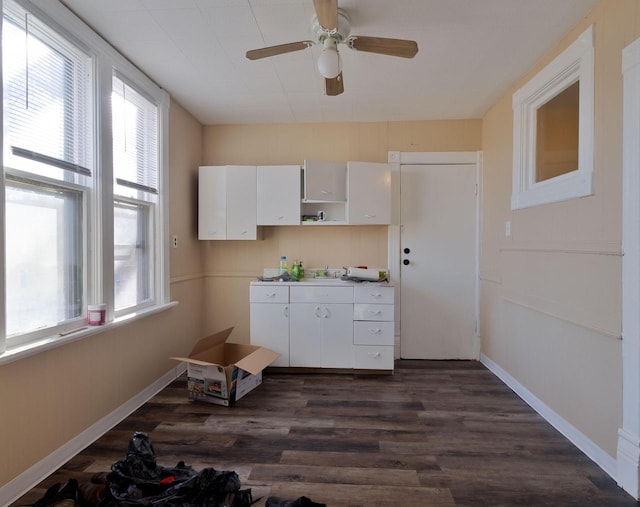 kitchen featuring dark wood-type flooring, white cabinetry, plenty of natural light, and a sink