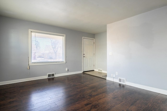 spare room featuring visible vents, baseboards, and wood finished floors