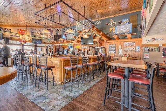 bar featuring a community bar, wooden ceiling, a towering ceiling, and wood finished floors