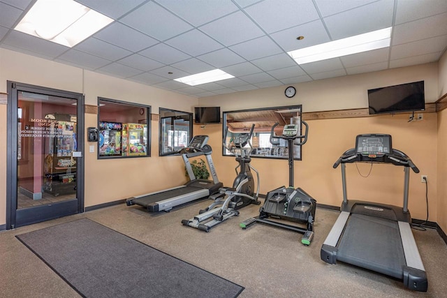 exercise room with a drop ceiling and baseboards