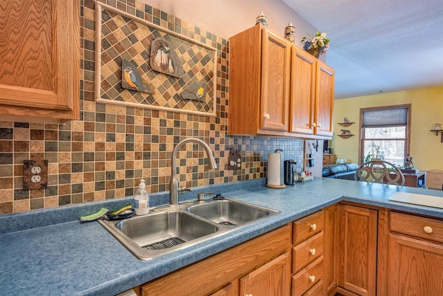 kitchen featuring brown cabinetry, backsplash, and a sink