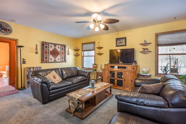 living area featuring a ceiling fan, a wealth of natural light, and carpet flooring