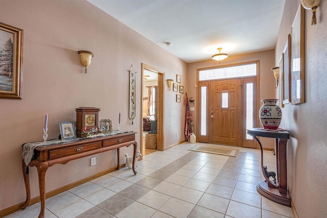 foyer entrance with light tile patterned floors and baseboards