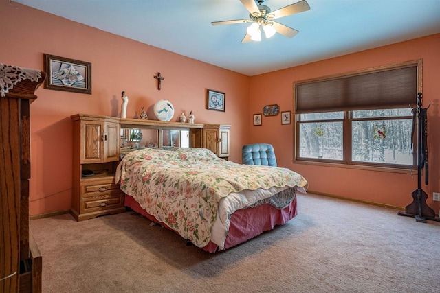 bedroom with light carpet, a ceiling fan, and baseboards