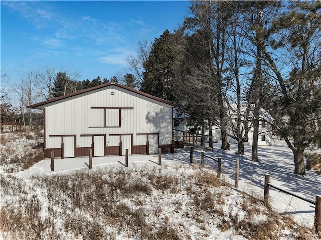 view of snowy exterior featuring an outbuilding and a pole building