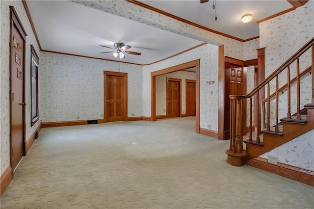 unfurnished living room with wallpapered walls, carpet, ceiling fan, and crown molding