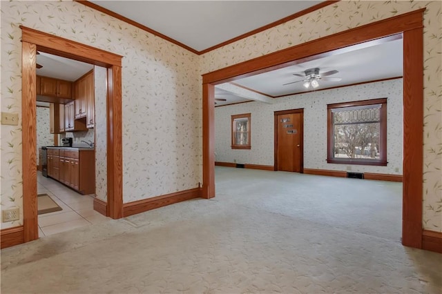 empty room featuring crown molding, light colored carpet, and wallpapered walls