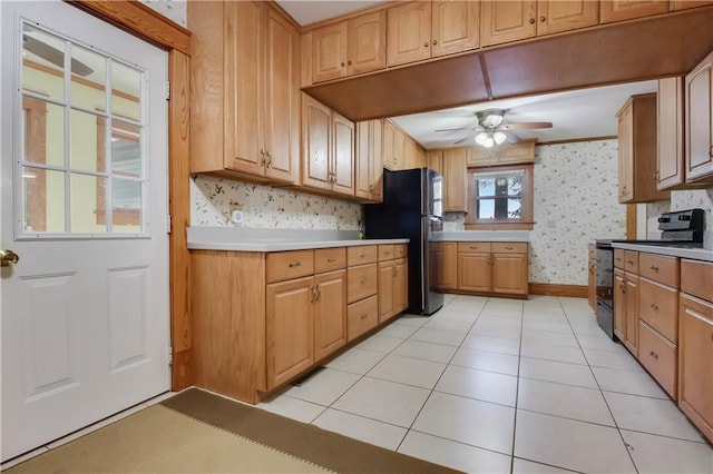 kitchen with ceiling fan, light tile patterned floors, light countertops, black appliances, and wallpapered walls