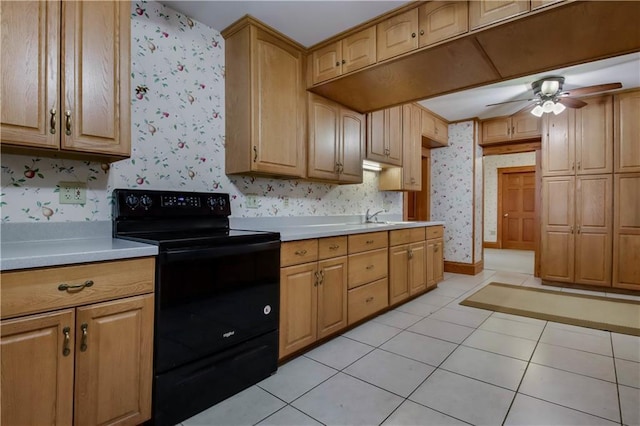 kitchen with light tile patterned flooring, baseboards, light countertops, black electric range oven, and wallpapered walls