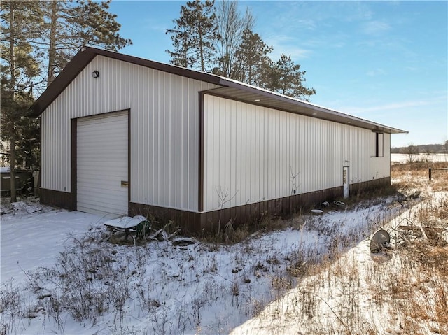 snow covered garage with a garage