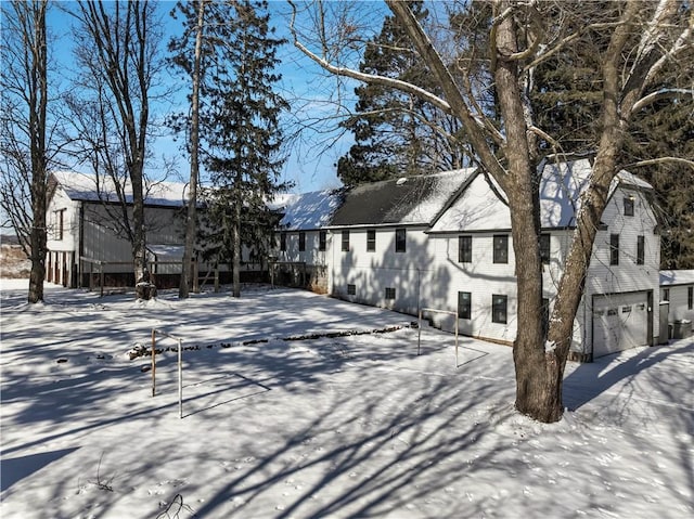 view of snow covered exterior with an attached garage